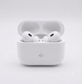 White wireless earbuds in a charging case on a light gray background
